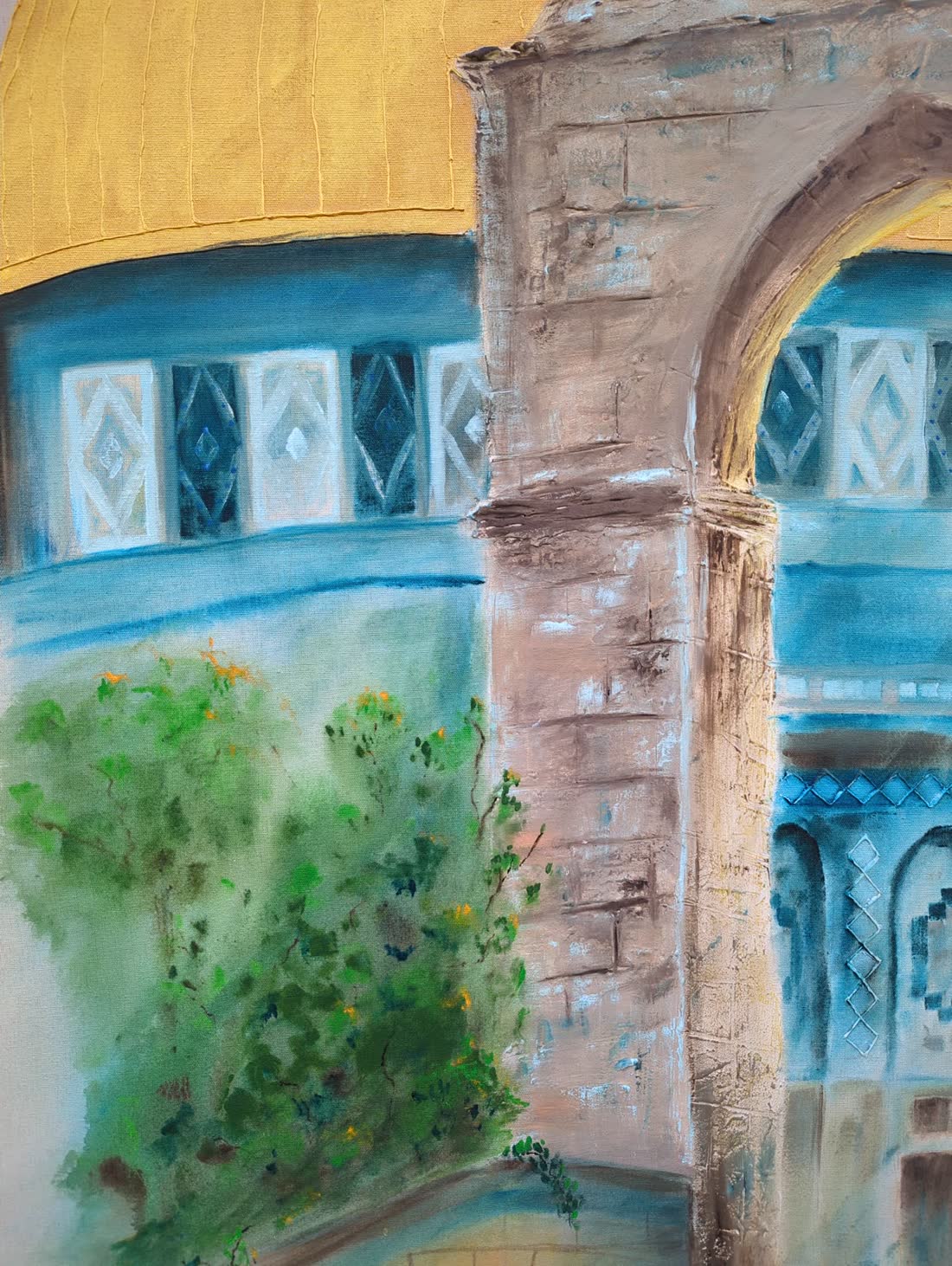 Detail: foliage worked in green against the pale stone.