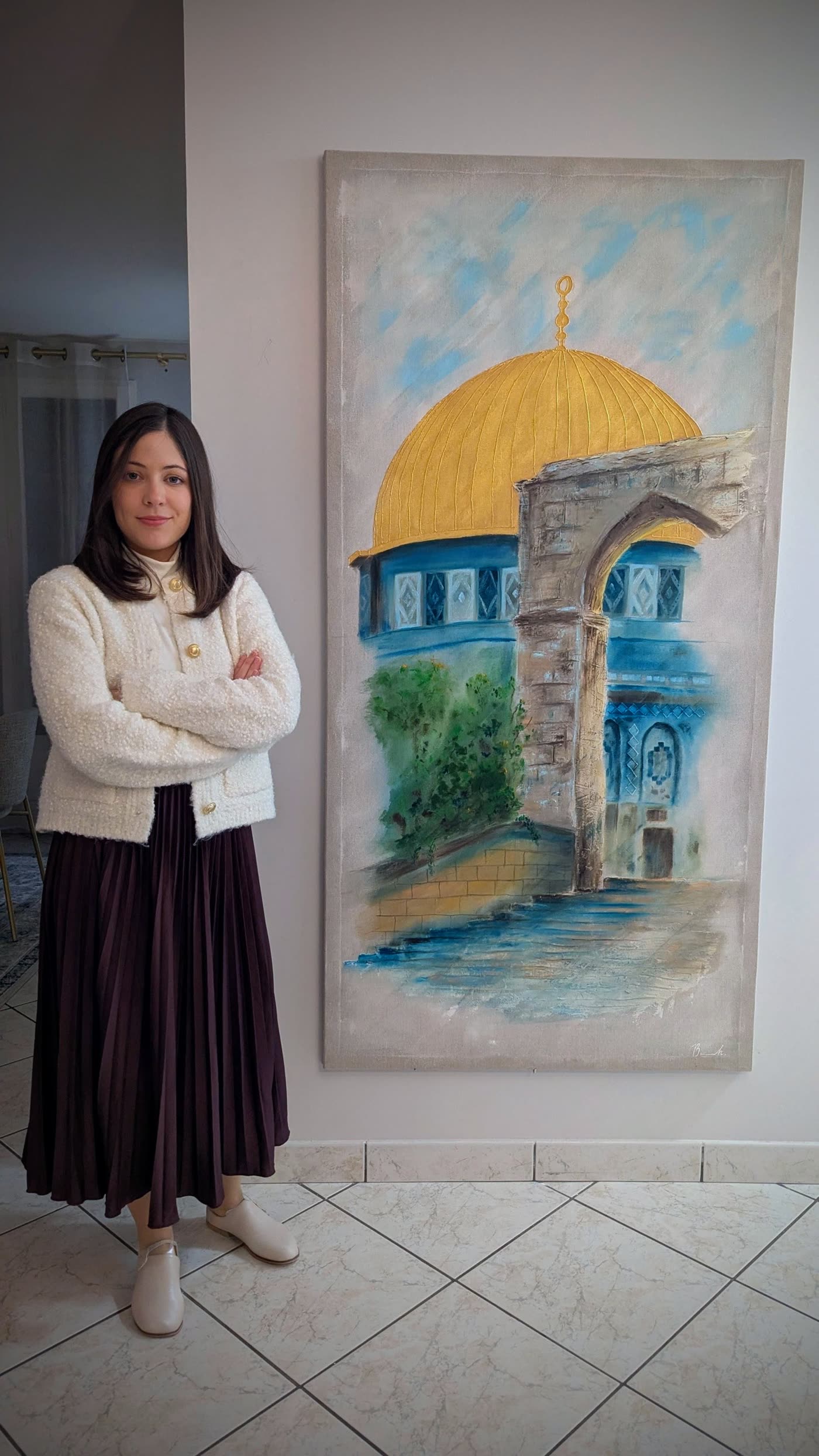 The artist standing beside the canvas, which reaches from her knee to well above her head.