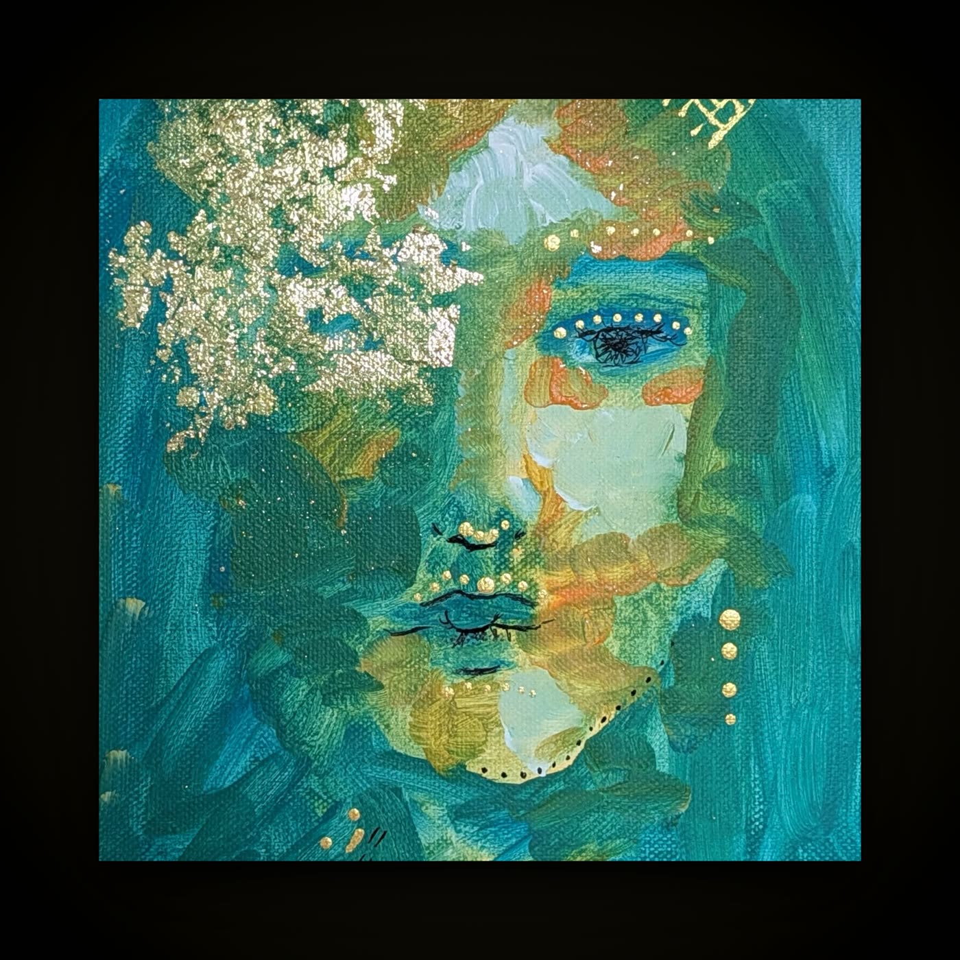 A framed painting of a woman's face in turquoise and gold, with white blossom across one side and gold beading.
